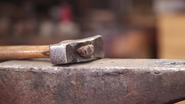 Blacksmiths hammer resting on the anvil with blurry background