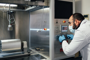 lab technician testing nanofiber on an electrospinning machine. biodegradable materials for...