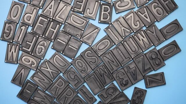 letterpress alphabet and numbers rotating on blue background