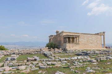 Obraz premium The ancient Erechtheion temple with beautiful Caryatids on Acropolis hill, famous tourist attraction in Athens, Greece, in sunny summer day