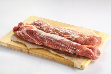 Raw pork tenderloin over board