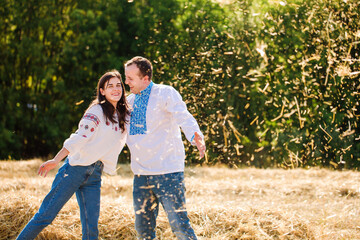 couple in have fun throwing hay