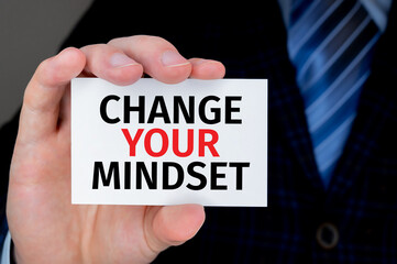businessman holding a card with text Change Your Mindset