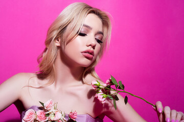 Woman with rose flowers on pink. Beauty portrait of beautiful female model.
