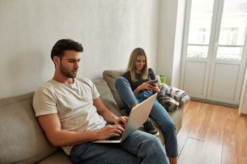 Obraz premium Young sporty man works hardly while his girlfriend watches funny content
