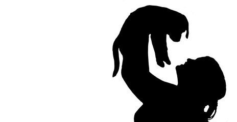 Silhouette of a girl holding up a puppy