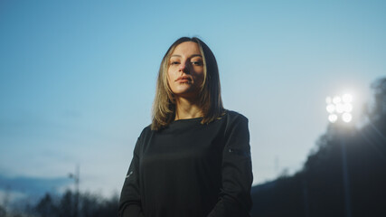 Portrait of attractive soccer player woman with stadium light.