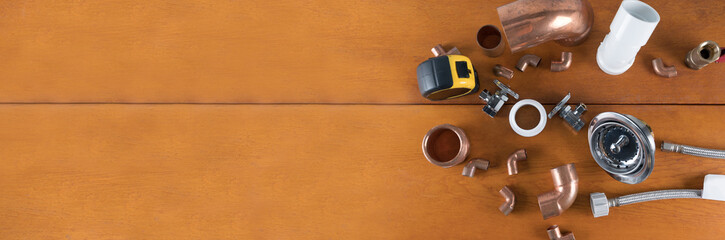 Different Plumbers tools and fittings on wood background. space for text.	