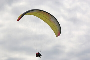 Tandem Paraglider in a cloudy sky