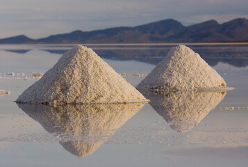 Piles of salt made by salt miners, dry during the rainy season in the Salar de Uyuni, Potosi, Bolivia