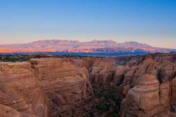 The sandstone cliffs of Arches National Park as seen from the Gemini Bridges area near Moab, UT at sunset