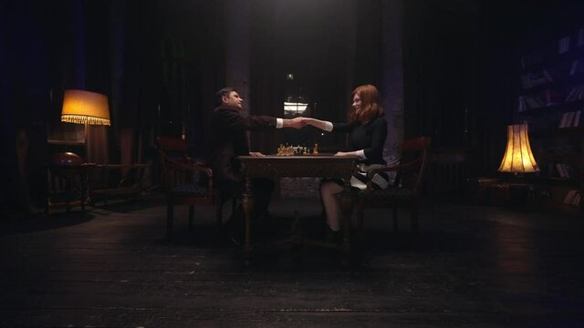 Two chess players man and woman play chess. Debut Accepted Queen's Gambit, King's Gambit, Philidor's Defense. Cinematic filming of a chess game. Antique chess board. This shot can be used for films