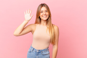 young pretty woman smiling and looking friendly, showing number five