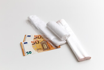 Plastic bags are on the 50 euro banknotes on the white background. Package, rolls