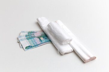 Plastic bags are on the ruble banknotes on the white background. Package, rolls