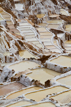 The Salinas salt pans are located in the Sacred Valley near Cusco, Peru. They have been used since the time of the Incas to extract salt from a hot-spring pouring out of the mountain side. The salt pans are artificial and the salty water is diverted to each pan and evaporation takes care of the rest. Once dry the salt is scraped, air-dried and put into sacks for transport. The salt is used for animal feed.