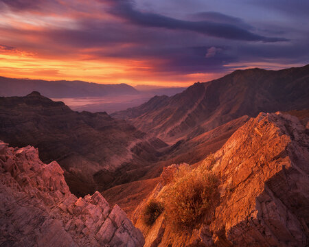 Warm reflected light from the sunrise gives gloss to the soft rock and valley below.