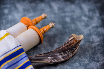 Prayer shawl in shofar horn on soft focus Jewish torah scroll