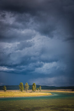 A bit of sun breaks through an afternoon thunderstorm over the Yellowstone River in the Hayden Valley, Yellowstone National Park.