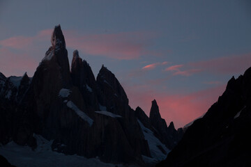 The silhouette outline of mountain peak of Cerro Torre against a pink sky in Patagonia, Argentina.