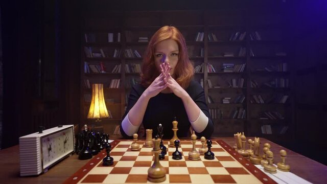 Two chess players man and woman play chess. Debut Accepted Queen's Gambit, King's Gambit, Philidor's Defense. Cinematic filming of a chess game. Antique chess board. This shot can be used for films.