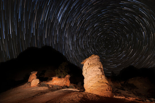 A unique rock formation along the Mt. Carmel Highway in Zion National Park stands out against a canopy of star trails in the northern sky.