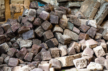 Many old cobblestones from the road are stacked