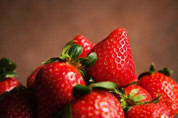 Ripe red strawberries macro. Close up strawberries on brown background. 