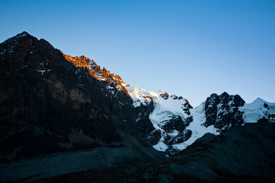 Early morning light hits the glacier-covered summits of Mt. Condoriri's Ala Derecha in Bolivia's Cordillera Real.