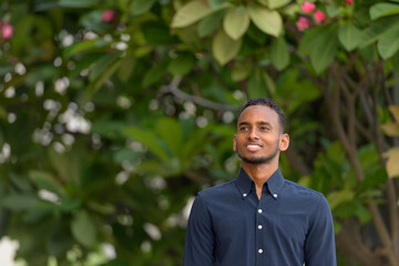 Handsome African businessman outdoors at rooftop garden thinking