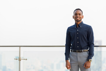 Handsome African businessman outdoors at rooftop smiling