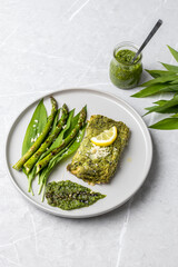 Salmon fillet with green wild garlic pesto. Green asparagus with salmon