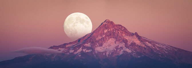 Full moon rising behind Mt Hood in sunset color