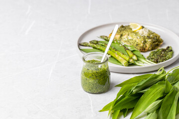 Wild garlic pesto. Green asparagus with salmon. Salmon fillet with green pesto. Wild garlic pesto in a glass