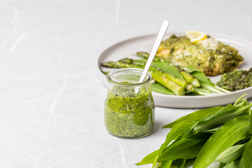 Wild garlic pesto. Green asparagus with salmon. Salmon fillet with green pesto. Wild garlic pesto in a glass