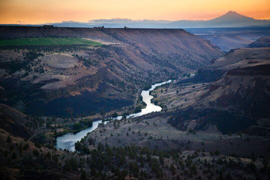 The sun sets behind Mount Hood as seen from the top of a route in Trout Creek, Oregon