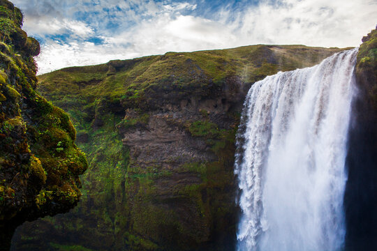 A rock formation which looks like a troll's head overlooks Skogafoss, a waterfall in Southern Iceland.