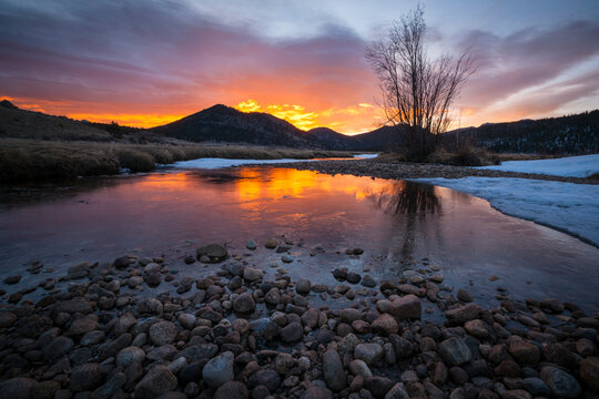 A fire lit the horizon and exploded into the clouds above Moraine Meadow, Rocky Mountain National Park.
