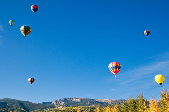 Fototapeta Hot air balloons rise above aspen groves in Snowmass Village, Colorado.