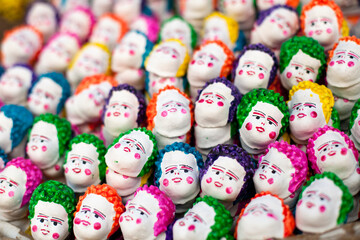 A strange amalgamation of finger like puppets with white painted faces, and colorful hair and cheeks.
