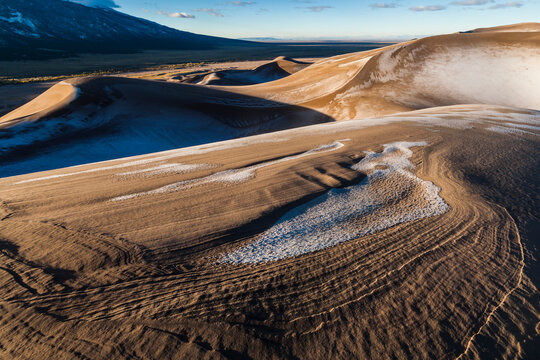 A dusting of snow covers the dunes at sunrise in Great Sand Dunes National Park, Colorado.