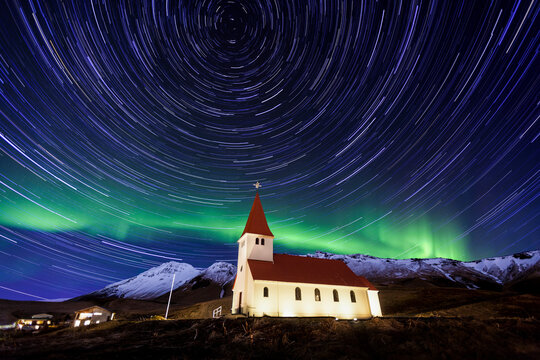 A traditional Icelandic church is framed by the stunning aurora borealis.