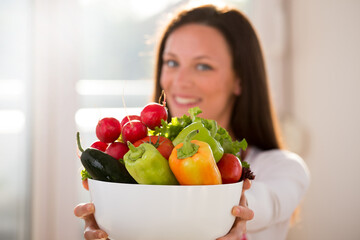 Woman holding bowl with vegetables