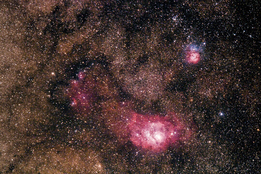 M8, the Lagoon Nebula, resting below M20, the Trifid Nebula in the Sagittarius constellation