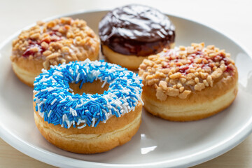 Four different donuts on white plate.