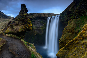 The face of a troll can be seen in the hills above the waterfall Skogafoss in Southern Iceland.