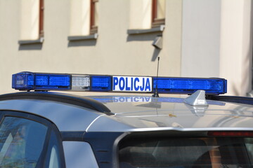 Radiowóz polskiej policji na patrolu w śródmieściu miasta.  Jedzie jezdnią.  © FotoDax