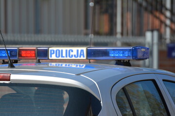 Radiowóz polskiej policji na patrolu w śródmieściu miasta.  Jedzie jezdnią.  - obrazy, fototapety, plakaty
