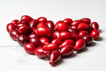 Heart shaped dogwood berries lie on a white background
