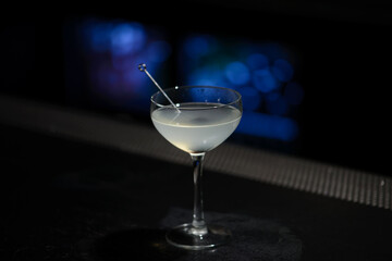 Classic martini cocktail  on bar table with blue lights in background